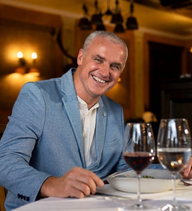 a man in a blue suit and a wine glass