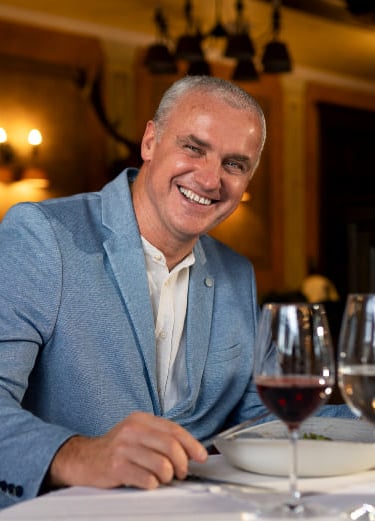 a man in a blue suit and a wine glass